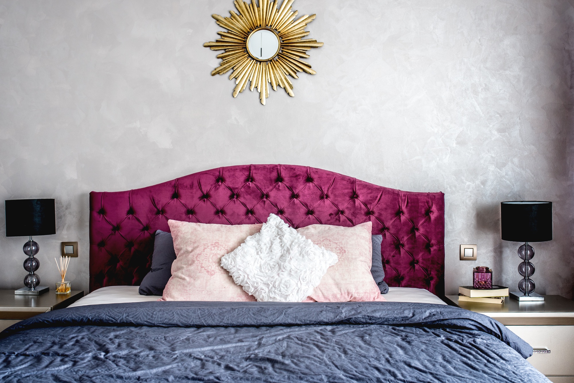 Luxurious bedroom interior with grey bedding and modern furniture. Bed details